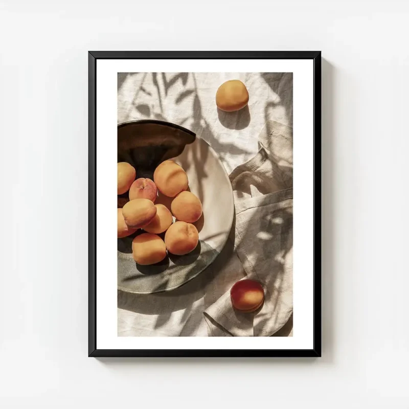 affiche dabricots frais dans une assiette sur une table avec des ombres de feuil avec cadre.webp