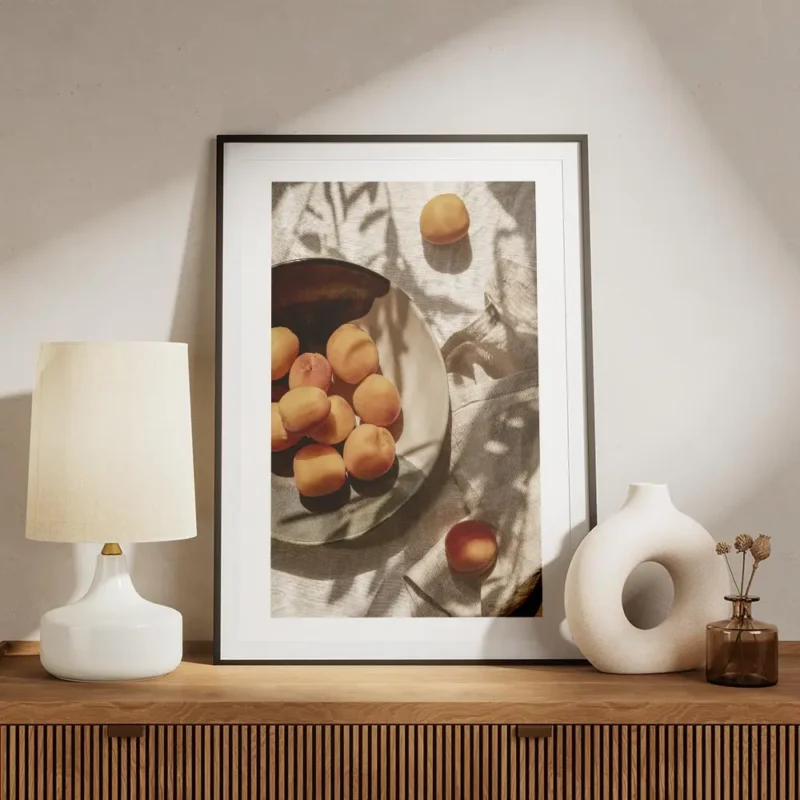 affiche dabricots frais dans une assiette sur une table avec des ombres de feuil meuble.webp