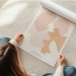 affiche dart abstrait aux formes fluides couleur peche et beige avec typographie en rouleau.webp