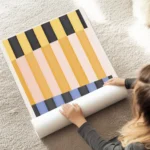affiche dart abstrait moderne avec des rayures colorees en jaune orange rose ble au sol.webp