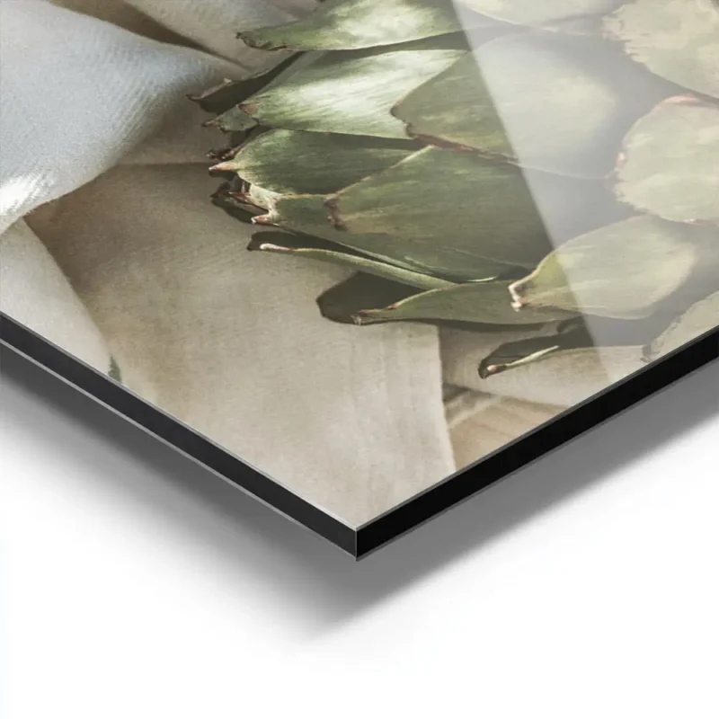 affiche dartichauts verts frais sur une assiette en ceramique blanche et un torc aluminium.webp