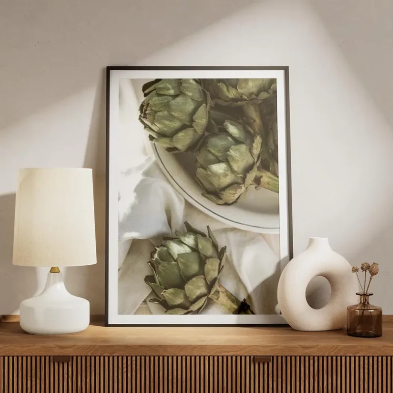 affiche dartichauts verts frais sur une assiette en ceramique blanche et un torc meuble.webp