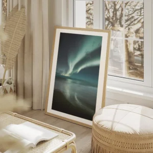 affiche daurores boreales bleues et vertes au dessus dune plage de sable sous un salon beige.webp