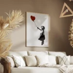 affiche de banksy fillette en noir tendant la main vers un ballon coeur rouge su salon.webp