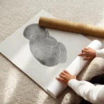 affiche de bebe gris avec texte personnalise typographie epuree sur fond clair enroule.webp