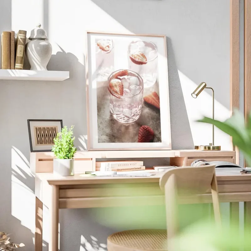 affiche de boisson rose avec des fraises et des glacons dans des verres sur une bureau.webp