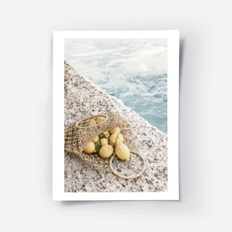 affiche de citrons jaunes dans un sac en filet sur un sol en pierre avec la mer .webp