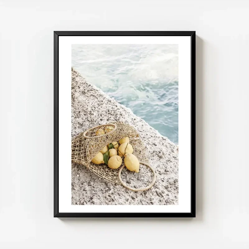 affiche de citrons jaunes dans un sac en filet sur un sol en pierre avec la mer avec cadre.webp