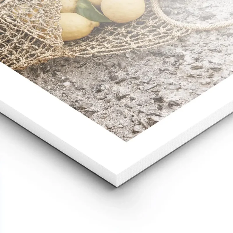 affiche de citrons jaunes dans un sac en filet sur un sol en pierre avec la mer lightpanel.webp