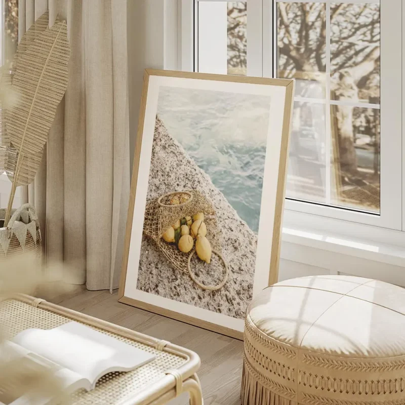affiche de citrons jaunes dans un sac en filet sur un sol en pierre avec la mer salon beige.webp