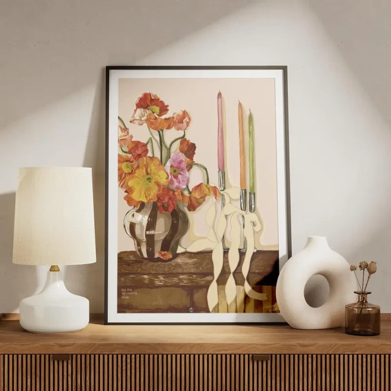 affiche de coquelicots colores dans un vase raye avec des bougies et rubans sur meuble.webp
