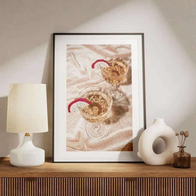 affiche de deux cocktails champagne rose dans des verres en cristal avec tranche meuble.webp