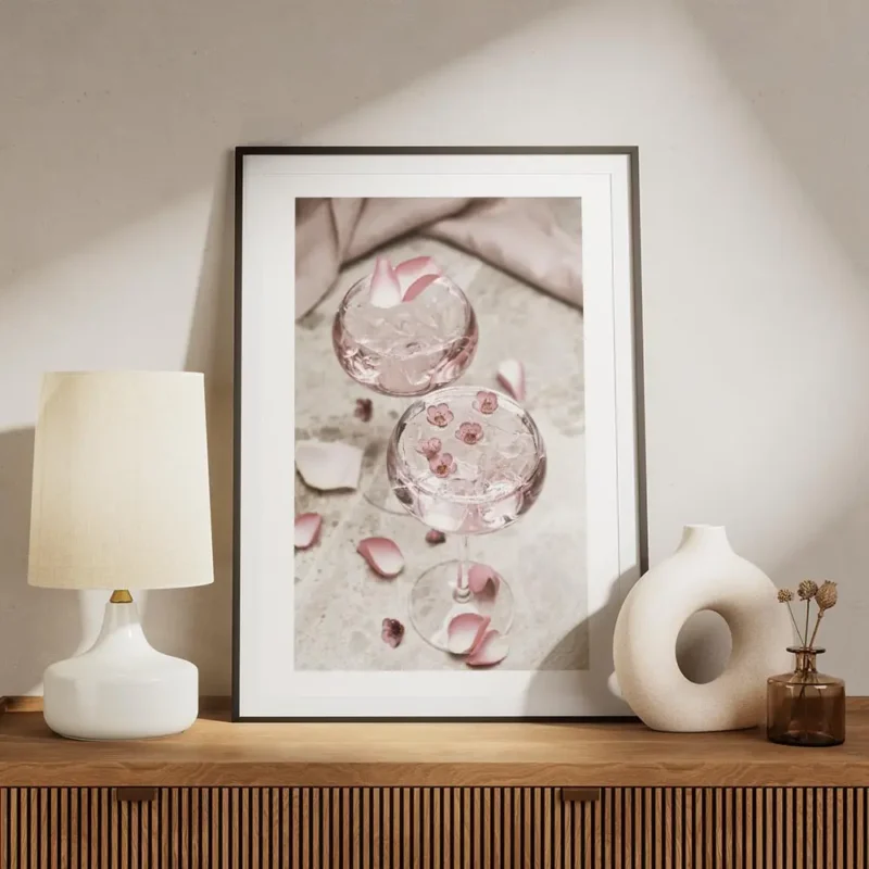 affiche de deux cocktails roses avec glacons decores de petales et petites fleur meuble.webp