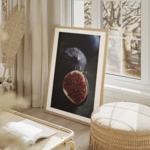 affiche de deux figues sombres lune coupee en deux revelant une chair rouge jute salon beige.webp