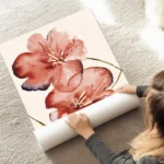 affiche de deux fleurs rouges corail aux nuances bleues et jaunes sur fond beige au sol.webp