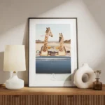 affiche de deux girafes en voiture decapotable bleue dans le desert avec une typ meuble.webp