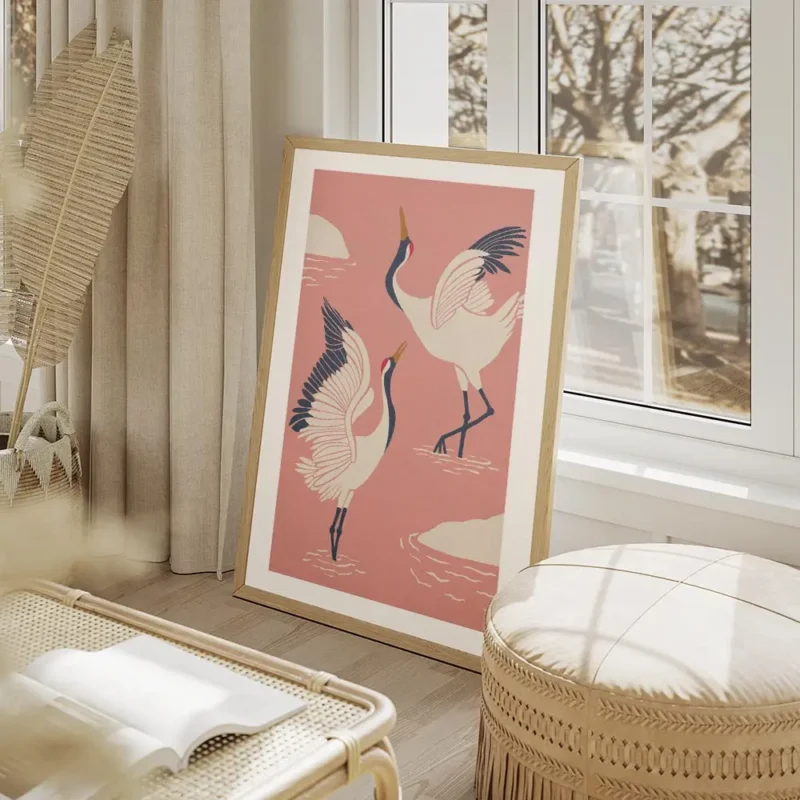 affiche de deux grues blanches dansantes avec des accents bleus et rouges sur un salon beige.webp