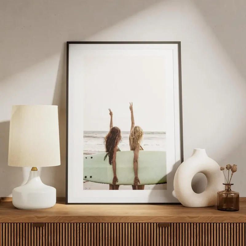 affiche de deux surfeuses avec une planche de surf faisant le signe de la paix s meuble.webp