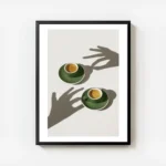 affiche de deux tasses de cafe vert sur soucoupes avec des ombres de mains sur l avec cadre.webp