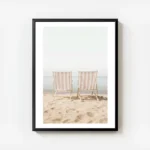 affiche de deux transats rayes beige et blanc sur une plage de sable ocean azur avec cadre.webp