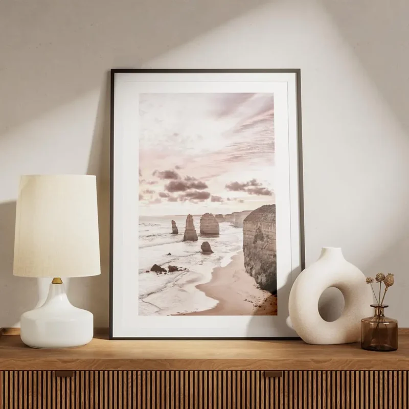 affiche de falaises oceaniques roses au lever du soleil avec une plage de sable meuble.webp