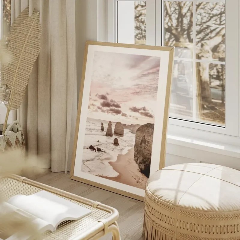 affiche de falaises oceaniques roses au lever du soleil avec une plage de sable salon beige.webp