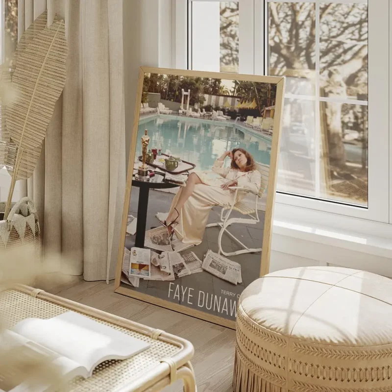 affiche de faye dunaway assise au bord dune piscine avec un oscar et des journau salon beige.webp