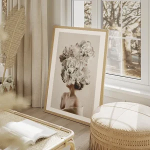 affiche de femme avec de grandes fleurs grises et beiges sur la tete sur un fond salon beige.webp