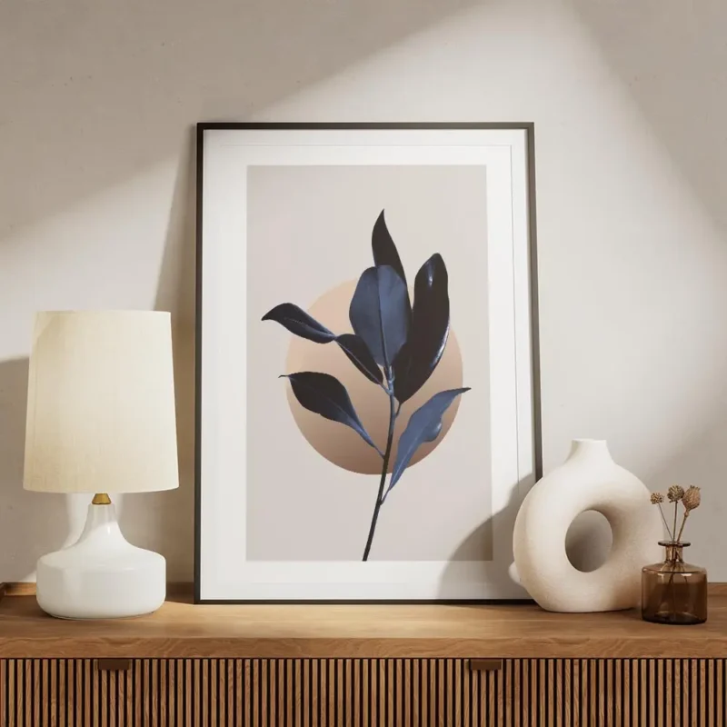 affiche de feuilles de magnolia bleu fonce avec un cercle illustre graphique sur meuble.webp