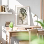 affiche de feuilles de monstera une verte et une doree posees sur un fond clair bureau.webp