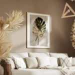 affiche de feuilles de monstera une verte et une doree posees sur un fond clair salon.webp