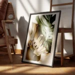 affiche de feuilles de monstera une verte et une doree sur un fond beige avec un encadre.webp