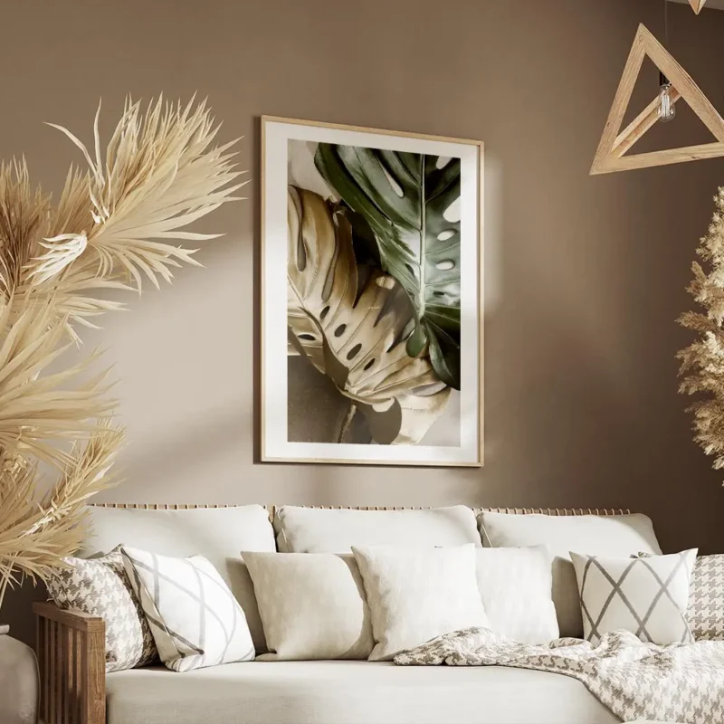 affiche de feuilles de monstera une verte et une doree sur un fond beige avec un salon.webp