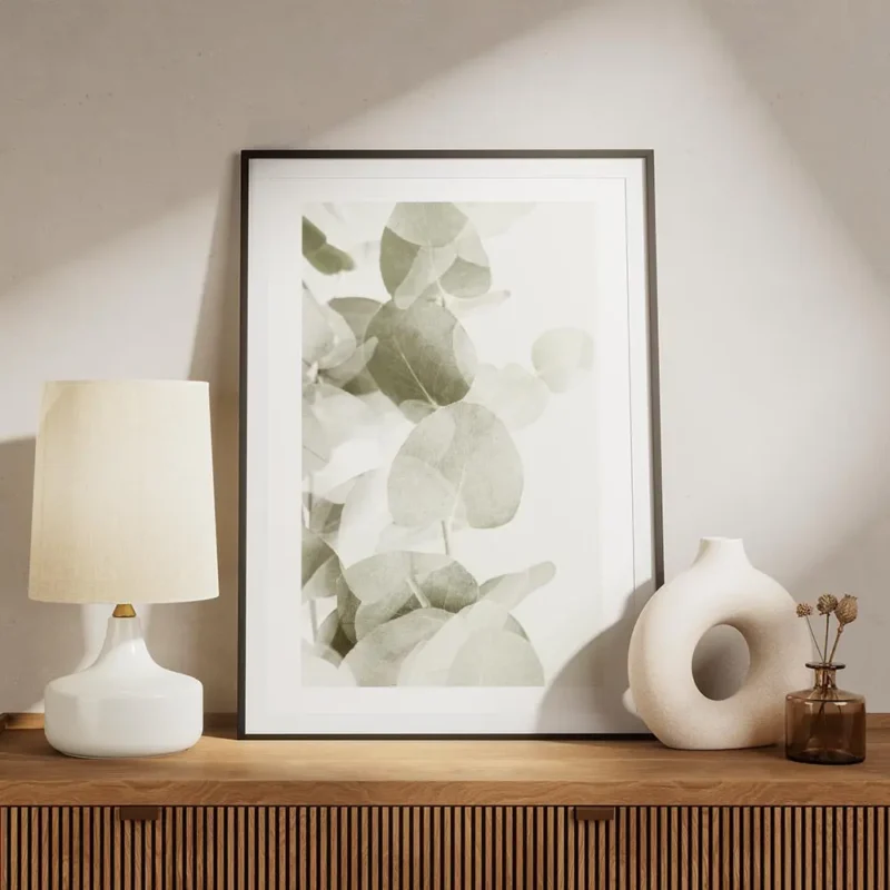 affiche de feuilles deucalyptus vert gris avec des ombres transparentes sur fond meuble.webp