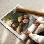 affiche de figues dete mures sur une assiette avec des feuilles vertes jouant su enroule.webp