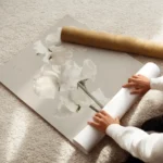 affiche de fleur blanche delicate avec tige verte sur fond beige clair enroule.webp