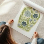 affiche de fleurs bleues et vertes stylisees dans un vase jaune pale avec des mo en rouleau.webp