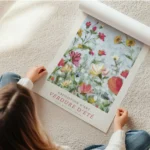 affiche de fleurs colorees en jaune rouge et rose sur fond bleu avec typographie en rouleau.webp