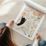 affiche de fleurs de feuilles et dune main noire en line art sur fond beige en rouleau.webp